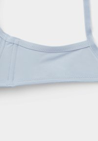 Lichtblauw bikini top met een eenvoudig ontwerp, voorzien van verstelbare schouderbanden, platte naden en een zachte, elastische textuur.