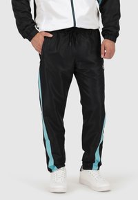 Zwarte sportbroek met lichtblauwe zijstrepen, elastische tailleband en zakken. Gemaakt van soepel, lichtgewicht materiaal.