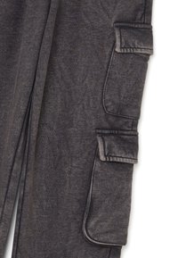 Dunkelgraue Stoffhose mit zwei rechteckigen Klappentaschen an der Seite, die detaillierte Nähte und strukturiertes Material zeigen.