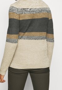 Gebreide trui met horizontale strepen in beige, bruin en donkergrijs. Losse pasvorm met gestructureerde stof en geribde manchetten.