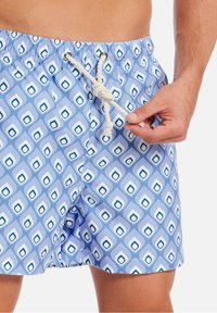 Costumi da bagno realizzati in un tessuto leggero, con un motivo geometrico blu e bianco, vita con cordoncino e tasche laterali.