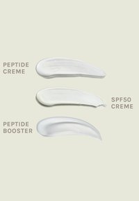 Drie romige witte productstalen: Peptide Crème, SPF50 Crème en Peptide Booster, elk met een gladde, dikke textuur op een lichte achtergrond.
