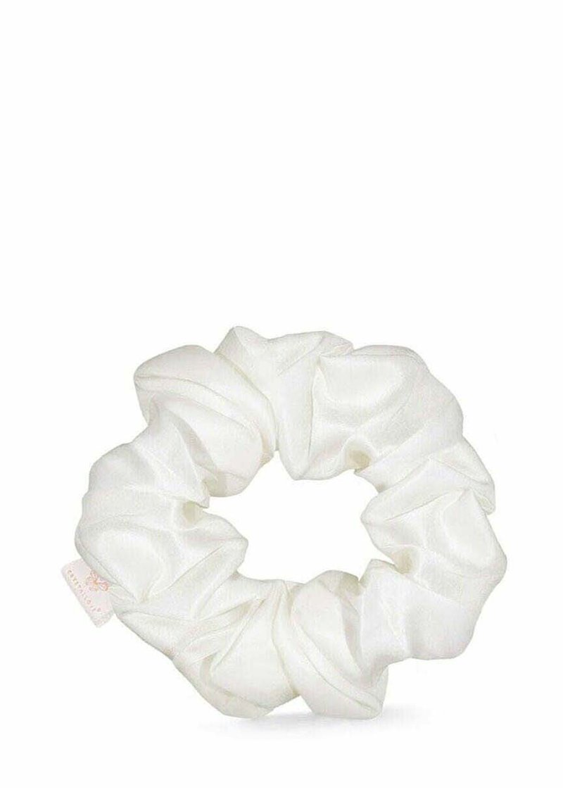 Biały satynowy scrunchie o teksturowanym, marszczonym wzorze, z bezszwowym okrągłym kształtem i małą metką przymocowaną do niego.