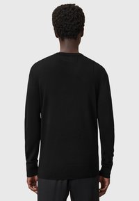 Schwarzer Pullover mit langen Ärmeln, rundem Halsausschnitt, glatter Textur, gerippten Bündchen und Saum sowie einem klaren, minimalistischen Design.
