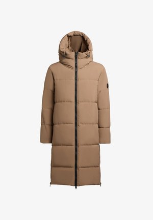 Világosbarna puffermellény magas gallérral, elülső cipzárral és steppelt panelekből készült. Kapucnival rendelkezik és minimál dizájn jellemzi.