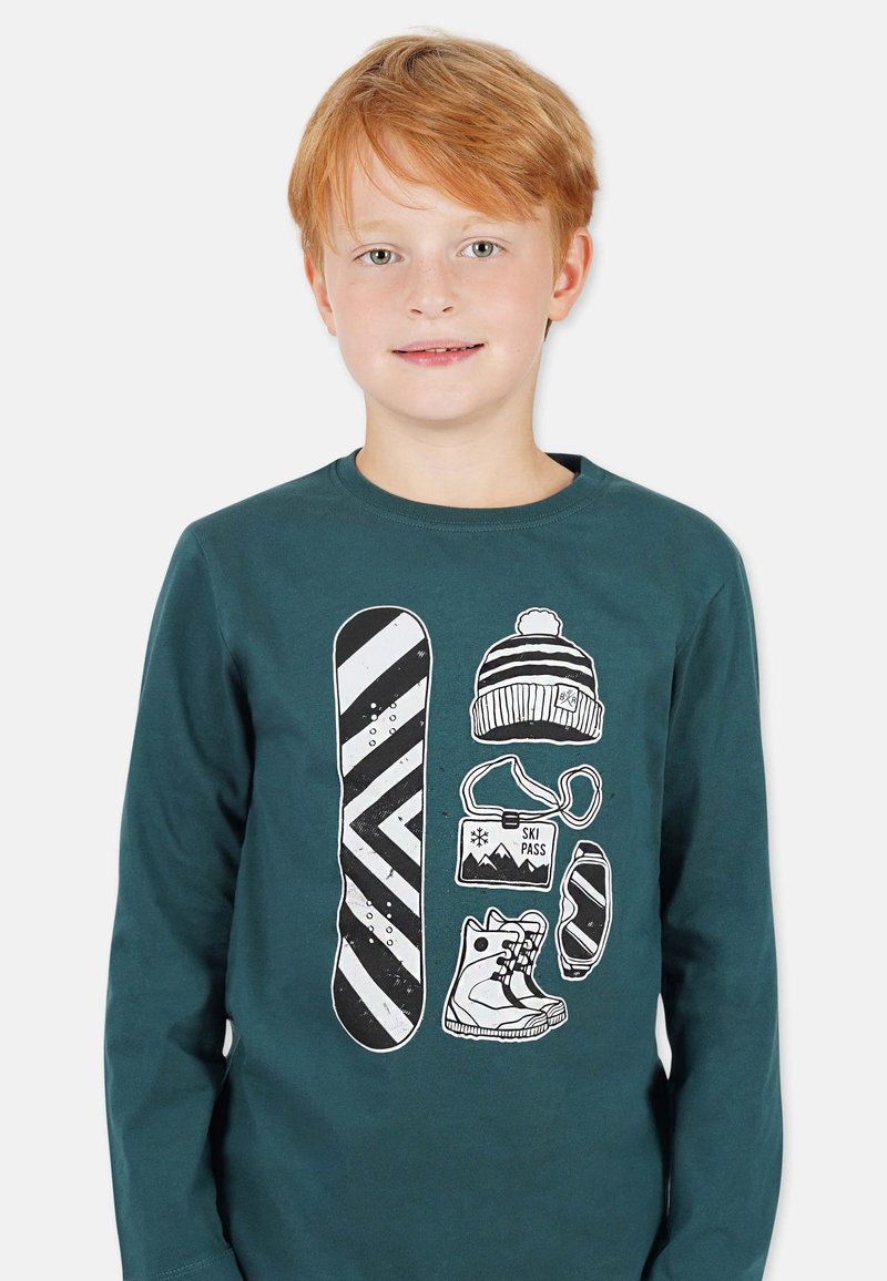 Dunkelblaues Langarmshirt mit einem weißen Grafikdesign von einem Snowboard, einer Mütze, einem Skipass und Skischuhen.