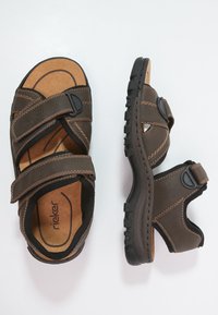 Braune Ledersandalen mit Klettverschlussriemen, Korkeinlage, strukturierten Gummisohlen und Kontrastnähten. Offenes Design für Atmungsaktivität.
