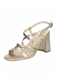 Strappy high-heeled sandal in metallic gold, featuring a block heel, open toe, and crisscross straps with a buckle closure. Smooth texture.