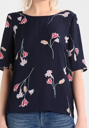 Blusa navy con maniche corte, caratterizzata da motivi floreali in rosso, rosa e giallo. Tessuto morbido e scollo ampio, orlo leggermente curvato.