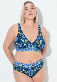 Blommig bikini-set med en mörkblå bas och gula samt blå blommor, v-ringning och breda axelband. Hög midja på underdelen med matchande mönster.