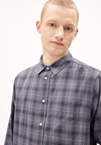 Geruite shirt in paarse en grijze tinten, gemaakt van lichtgewicht stof. Heeft een kraag, knopenrij aan de voorkant en een enkele borstzak.