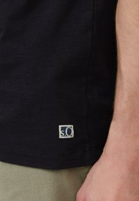 Donkerblauwe t-shirt met een klein wit label met het "s.Oliver" logo in de onderste hoek; de stof ziet er zacht en glad uit.