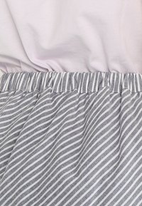 Haut violet clair avec jupe froncée à rayures grises. Le matériau semble doux ; la jupe présente des fines rayures blanches sur un fond gris.