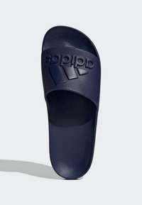 Infradito blu navy realizzati in materiale sintetico testurizzato, con logo in rilievo e tre strisce decorative sulla tracolla. Design open-toe.