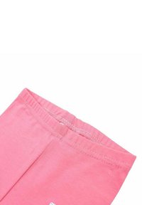 Leggings en coton rose avec une texture douce, taille élastique et un petit détail étiquette près de l'ourlet. Design simple, sans motifs.