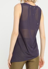 Ärmör tärningslila träningslinne gjort av lätt, genomskinligt tyg; har en rundade halsringning och en avslappnad passform.