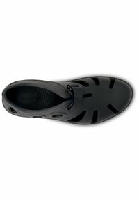 Black, molded shoe with an open design, featuring ventilation holes, a textured insole, and an adjustable strap for secure fit.
