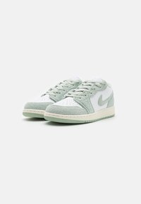 Sneakers bianchi e verde menta con una tomaia in pelle liscia, accenti in suede, punta perforata e suola in gomma con battistrada testurizzato.