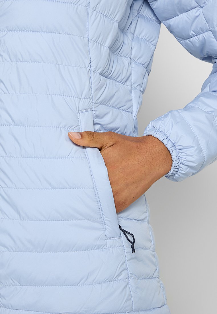 Giacca puffer azzurro chiaro con motivo trapuntato, polsini elasticizzati e tasca laterale. Tessuto liscio e lucido con una leggera brillantezza e dettagli con cordoncino.