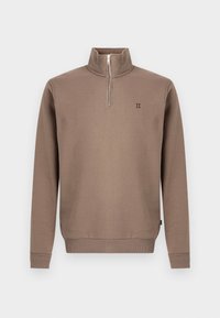 Brązowa bluza z zamkiem do ćwiartek i wysokim kołnierzem, z prążkowanymi mankietami i dołem, z małym czarnym logo na piersi. Gładka faktura materiału.