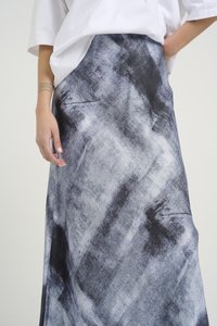 Saia longa com um padrão abstrato em preto e branco, feita de um tecido suave. Apresenta um design fluído, textura suave e um ajuste descontraído.