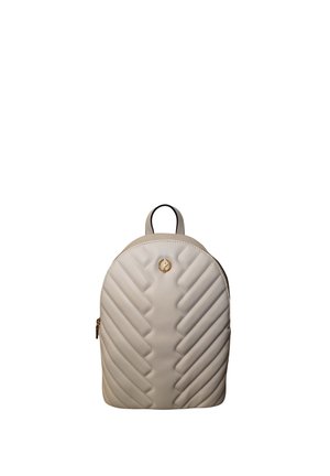 Piccolo zainetto beige trapuntato con parte superiore arrotondata, cerniera dorata e piccolo emblema dorato sulla parte anteriore, isolato su sfondo bianco.