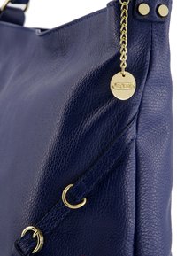 Navyblauwe leren handtas met een gestructureerde afwerking, gouden hardware accenten, kettingdetail en merketiket, met een gestructureerde vorm.