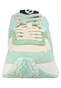 Light green and cream athletic shoe with suede and mesh materials, textured sole, lace-up front, and a black logo on the tongue.