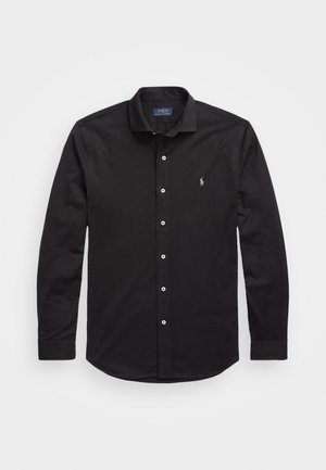 Chemise noire à manches longues boutonnée avec col, boutons blancs et petit logo blanc Polo Ralph Lauren sur la poitrine gauche.
