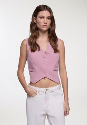 Top corto rosa chiaro con scollatura a V, bottoni frontali e due tasche laterali. Realizzato in tessuto morbido, presenta un design aderente e una forma strutturata.