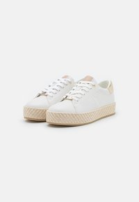 Baskets en cuir blanc avec une plateforme en jute tressé, présentant des accents dorés et un design à lacets, texture lisse et forme de bout arrondi.