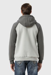 Kapuzensweatshirt mit grauen Ärmeln und einem hellgrauen Körper, ausgestattet mit gerippten Bündchen, Saum und einer Kängurutasche an der Vorderseite.