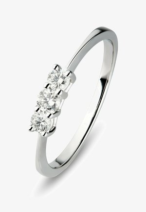 Schmaler silberner Ring mit drei runden Diamanten in einer Reihe auf weißem Hintergrund.