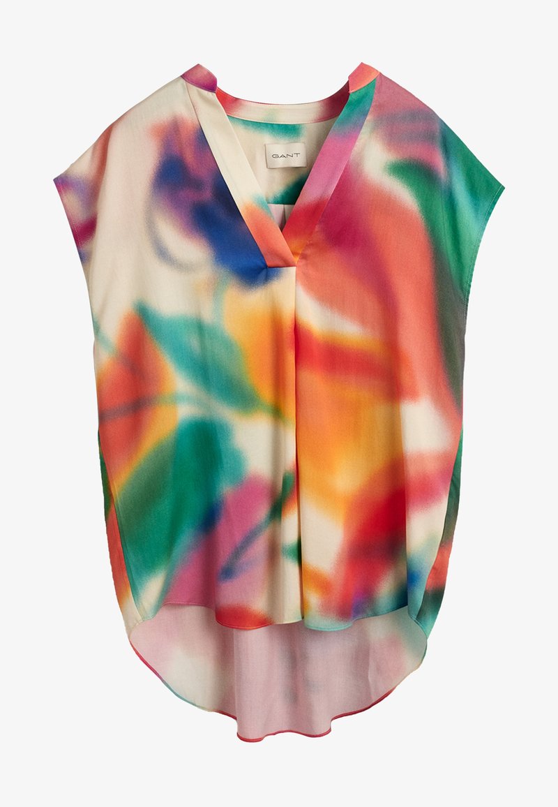 Blouse sans manches à col en V avec une coupe ample et un motif abstrait multicolore tie-dye dans des tons rouges, orange, vert, bleu et violet.