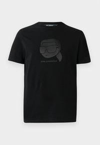 Melnas kokvilnas T-krekls ar matētu melnu grafiku, kurā attēlots varonis ar saulesbrillēm un zem tā uzraksts "KARL LAGERFELD". Regulāra piegriezuma, īsām piedurknēm.
