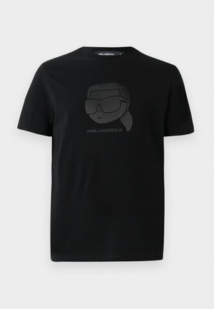 Juodas medvilnės marškinėliai su matinės juodos spalvos grafika, vaizduojančia veikėją su akiniais nuo saulės ir tekstu "KARL LAGERFELD" žemiau. Reguliarus kirpimas, trumpomis rankovėmis.