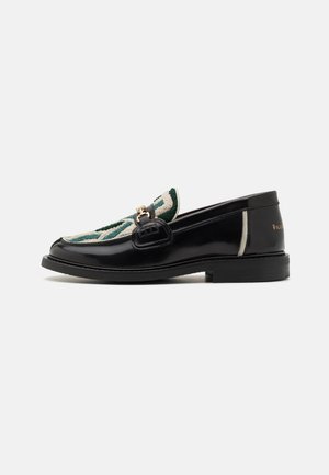 Black leather loafer with embroidered green and cream pattern. Features a gold-toned hardware accent and a flat rubber sole.