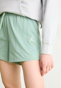 Mint zelena kratka hlače izrađene od mekog materijala, s elastičnom navlakom u struku i suptilnim bijelim Jumpman logom na lijevoj strani.