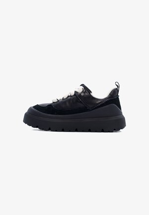 Sneaker in pelle nera e suede con suola in gomma spessa, punta tonda e lacci bianchi a contrasto. Caratterizzata da una linguetta sul tallone.