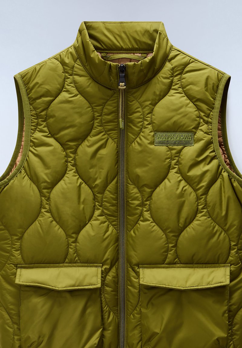 Oliwkowa, pikowana kamizelka z wysokim kołnierzem, zamkiem błyskawicznym z przodu i dwiema kieszeniami z przodu. Teksturowana w wypukłe owalne wzory z metką marki.