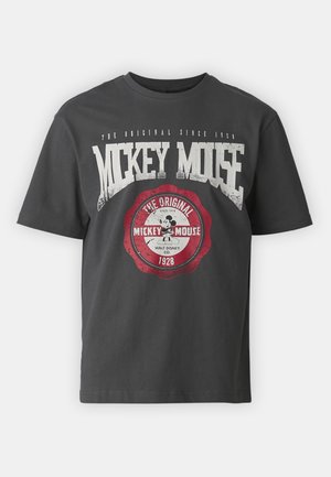 T-shirt gris foncé avec texte blanc usé "Mickey Mouse" et un emblème circulaire rouge présentant le Mickey Mouse classique et la date "Depuis 1928".