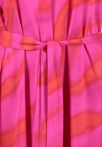 Fuksjowa sukienka z paskiem do wiązania, wyróżniająca się gładką tkaniną, swobodnym krojem oraz subtelnymi poziomymi paseczkami w jaśniejszych odcieniach pomarańczowego.