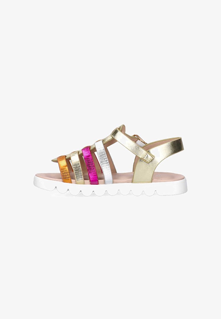 Sandalias metálicas doradas con tiras multicolores (dorado, naranja, plata, rosa, blanco) y una suela blanca con borde festoneado. Diseño de espalda abierta.
