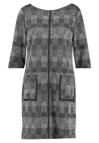 Abito a maniche tre quarti in bianco e nero con scollatura a barca e due tasche frontali. Design a quadretti texture.