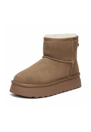 Brun ruskind ankle støvle med tyk sål og hvid fleeceforing, designet til varme og afslappet brug.