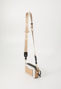 Borsa rettangolare compatta in colore beige, nero e bianco. Presenta una tasca frontale, hardware dorato e una tracolla regolabile con logo.