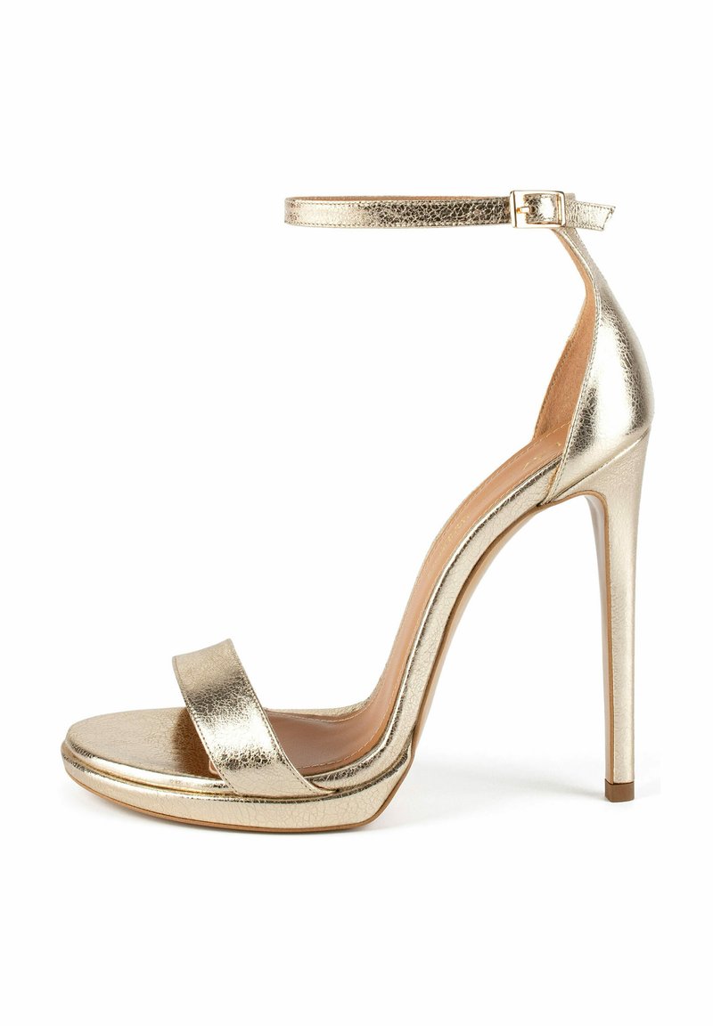 Sandal alta in metallo dorato con sottile cinturino alla caviglia, punta aperta e design elegante. Presenta una soletta imbottita e un tacco a spillo.