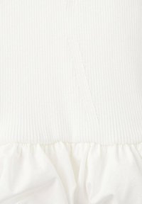 Rochie albă cu o parte superioară nervurată și o fustă plisată. Textura este netedă, cu o culoare uniformă, tranziție fără cusături între materiale.