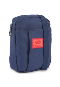 Bolso de tela azul marino con cierre de cremallera, correa ajustable y un bolsillo frontal que presenta un parche con el logotipo rojo de Skechers. Diseño compacto.