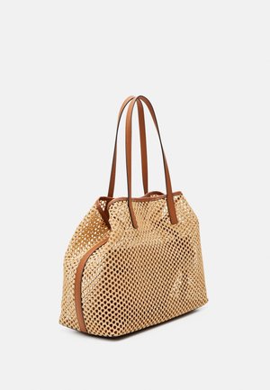 Sac cabas tissé beige avec garniture en cuir marron et double bandoulière, présenté sur un fond uni gris clair.